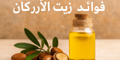 زجاجة زيت الأركان النقي مع ثمار الأركان الطازجة والخلفية الطبيعية – فوائد زيت الأركان